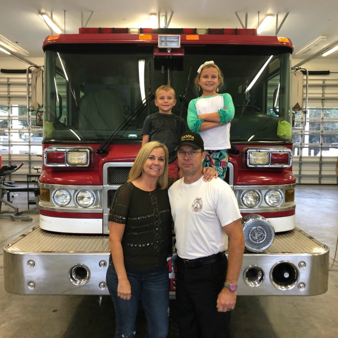 Irons and Antlers family standing in front of a fire engine