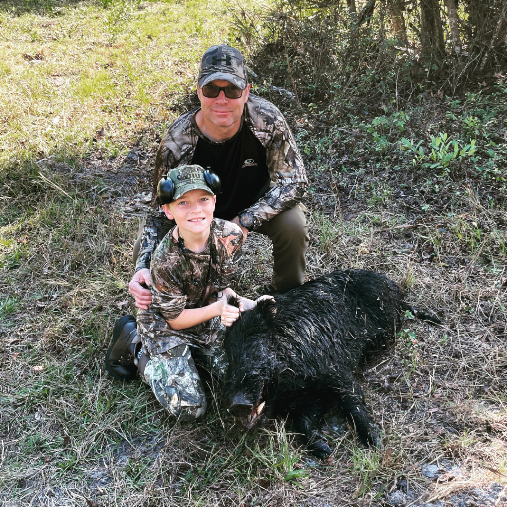 Father and son with a harvested wild boar